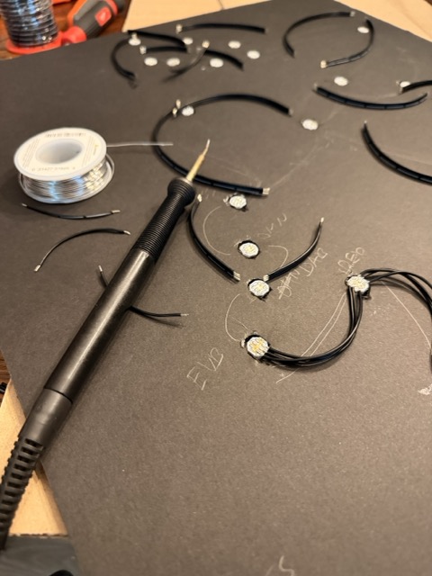LED nodes being soldered by hand onto a map backing board